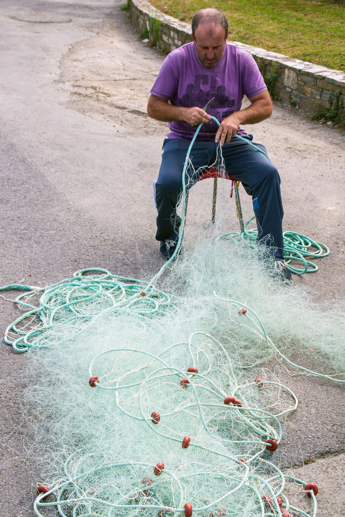 Fisherman fixing fishing net